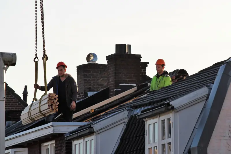 Roofers installing a roof on a house under construction